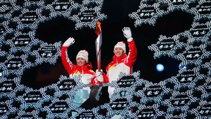 Dinigeer Yilamujiang a porté le dernier relais de la torche olympique avec Zhao Jiawen, lors de la cérémonie d'ouverture des Jeux de Pékin, le 4 février 2022. (LIU XU / XINHUA / AFP)