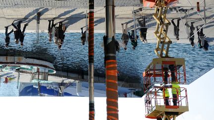 Des ouvriers installent des miroirs sur le Vieux-Port de Marseille (Bouches-du-Rh&ocirc;ne) selon les voeux de l'architecte britannique Norman Foster, le 19 f&eacute;vrier 2013. (ANNE-CHRISTINE POUJOULAT / AFP)