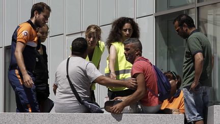 Tahar Mejri&nbsp;(avec le tee-shirt rose) en larmes devant l'hôpital Pasteur de Nice (Alpes-Maritimes), le 16 juillet 2016. (ALBERTO ESTEVEZ / EFE)