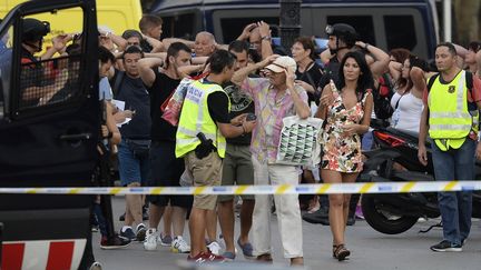 Des enquêteurs contrôlent l'identité de passants restés confinés après l'attentat de La Rambla, à Barcelone (Espagne), le 17 août 2017.&nbsp; (JOSEP LAGO / AFP)