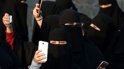 Des saoudiennes armées de leurs téléphones portables lors du Festival national du patrimoine et de la culture Al-Janadriyah, le 8 février 2016, dans le village d'Al-Thamama au nord de Riyad. Elles sont des milliers à se rallier, sur Twitter, à la campagne pour «faire tomber la tutelle masculine». (FAYEZ NURELDINE/AFP)