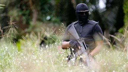 Un policier des forces spéciales malaisiennes protège, le 19 février 2013, une zone autour d’un village situé près de Lahad Datu, dans l'Etat de Sabah, au nord de Bornéo. Des Philippins armés s’y sont installés. (REUTERS / Bazuki Muhammad)