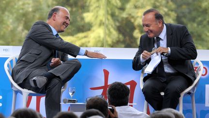 Pierre Moscovici tend la main &agrave; Pierre Gattaz, lors du d&eacute;bat r&eacute;unissant les deux hommes &agrave; l'universit&eacute; de Medef, le 29 ao&ucirc;t 2013, &agrave; Jouy-en-Josas (Yvelines). (ERIC PIERMONT / AFP)