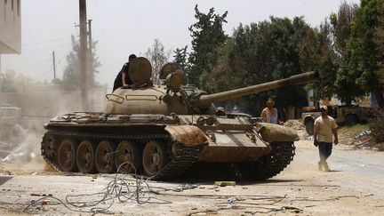 Des combattants&nbsp;des forces loyales au gouvernement d'union nationale (GNA) dans la région d'al-Sawani au sud de Tripoli, la capitale libyenne, lors d'affrontements avec les pro-Haftar, le 13 juin 2019. (MAHMUD TURKIA / AFP)