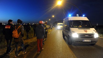 Des migrants passent devant une fourgonnette&nbsp;de CRS, dimanche 2 ao&ucirc;t 2015 &agrave; Calais (Pas-de-Calais). (FRANCOIS LO PRESTI / AFP)