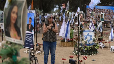 Une femme visite, le 6 octobre 2024, le lieu de recueillement en hommage aux personnes disparues dans l'attaque du festival Tribe of Nova, à Réim (Israël). (MENAHEM KAHANA / AFP)