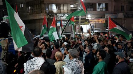 Des personnes réunies à Atme (Syrie) brandissent le drapeau palestinien le 17 octobre 2023, à la suite de l'explosion qui a touché l'hôpital de Gaza. (RAMI AL SAYED / AFP)