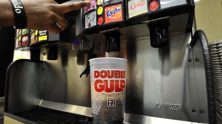 Un homme se sert un soda g&eacute;ant, le 11 mars 2013,&nbsp;dans un commerce new-yorkais. (TIMOTHY A. CLARY / AFP)