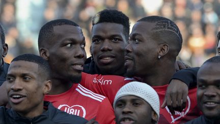 Le footballeur Paul Pogba (au centre) avec ses frères Florentin (à gauche) et Mathias à droite), réunis lors d'un match de gala en 2019. (GUILLAUME SOUVANT / AFP)