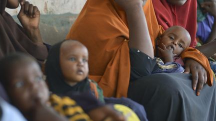 Des enfants souffrant de malnutrition attendent avec leur mère devant un centre d'aide de l'Unicef à Baidoa, en Somalie, le 15 mars 2017. (TONY KARUMBA / AFP)