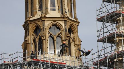 Des ouvriers participent à la reconstruction de la nouvelle flèche en bois de la cathédrale Notre-Dame de Paris partiellement recouverte de plomb, à Paris, le 14 mars 2024. (Ludovic MARIN / AFP)