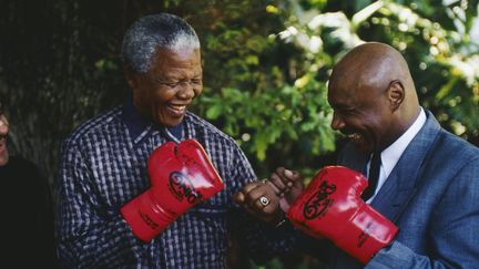 L'ancien président sud-africain Nelson Mandela avec l'ancien champion du monde de boxe américain Marvin Hagler. Cette photo non datée a été prise après la libération de Mandela.&nbsp; (LOUISE GUBB/GETTY IMAGES)