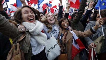 Des partisans d'Emmanuel Macron exultent après l'annonce de la victoire de leur champion, dimanche 7 mai à Paris. (PATRICK KOVARIK / AFP)