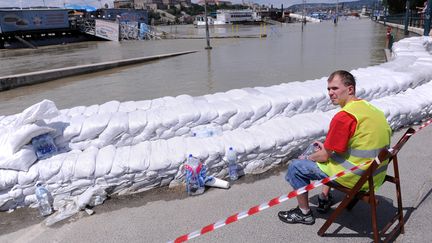 Un homme surveille les bords du Danube &agrave; Budapest (Hongrie) le 10 juin 2013 (ATTILA KISBENEDEK / AFP)