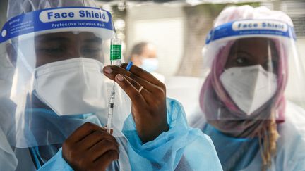 Des soignants d'un hôpital de Madagascar préparent une dose de vaccin AstraZeneca, le 10 mai 2021. (RIJASOLO / AFP)