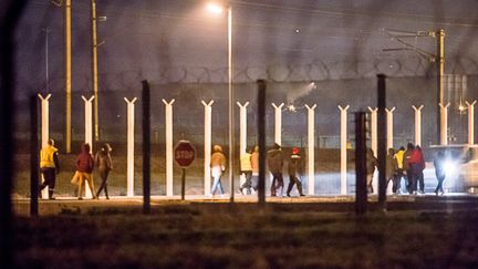 Des agents de s&eacute;curit&eacute; escortent des migrants apr&egrave;s une intrusion dans le tunnel sous la Manche, le 3 octobre 2015, pr&egrave;s de Calais (Pas-de-Calais). (PHILIPPE HUGUEN / AFP)