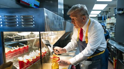 Donald Trump derrière un comptoir lors d'un événement pendant campagne présidentielle dans un restaurant McDonald's, le 20 octobre 2024, à Feasterville-Trevose, en Pennsylvanie. (GETTY IMAGES NORTH AMERICA / AFP)