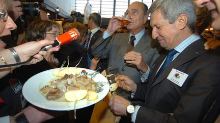 Et les agriculteurs le lui rendent bien. Comme ici, en 2007, où on offre bière, tête de veau et pomme au chef de l'Etat. (MAXPPP)