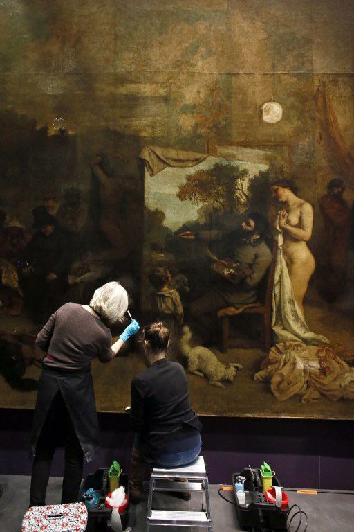 Deux restauratrices interviennent sur "L'Atelier du peintre" de Gustave Courbet, au musée d'Orsay en décembre 2014
 (PATRICK KOVARIK / AFP)