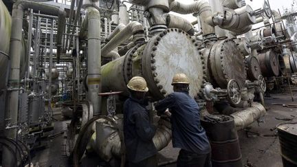 Ouvriers nigérians intervenant dans une raffinerie de pétrole à Port Harcourt (sud du Nigeria), le 16 septembre 2015. (AFP - PIUS UTOMI EKPEI)