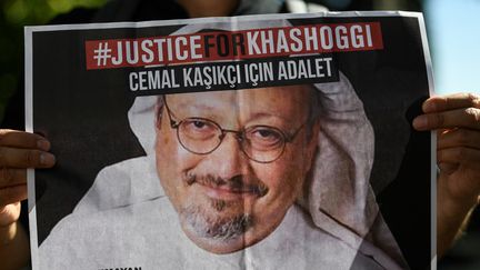 Un poster montrant le visage du journaliste saoudien&nbsp;Jamal Khashoggi, tendu par un de ses amis, devant le consulat d'Arabie Saoudite à Istanbul, en octobre 2020. (OZAN KOSE / AFP)