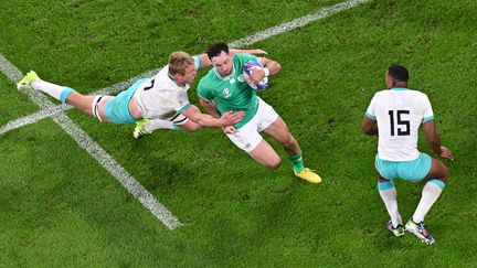 L'Irlandais Hugo Keenan tente de se frayer un passage dans la défense de l'Afrique du Sud, le 23 septembre 2023, en Coupe du monde, au Stade de France. (MIGUEL MEDINA / AFP)