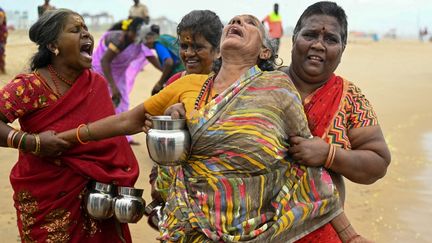 Une femme pleure en effectuant des rituels, toujours sur la plage de Pattinapakkam (Inde). (R.SATISH BABU / AFP)