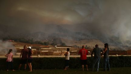 Des personnes regardent un incendie à Corona (Californie), le 9 août 2018. (MARIO TAMA / GETTY IMAGES NORTH AMERICA / AFP)