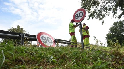 Des employés de la direction interdépartementale des routes de l'Est remplacent des panneaux de limitation de vitesse, près de Wittenheim (Haut-Rhin), le 29 juin 2018. (SEBASTIEN BOZON / AFP)