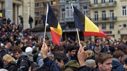 Des Belges brandissent des drapeaux place de la Bourse &agrave; Bruxelles, le 23 mars 2016. (CITIZENSIDE /OLIVIER GOUALLEC / AFP)