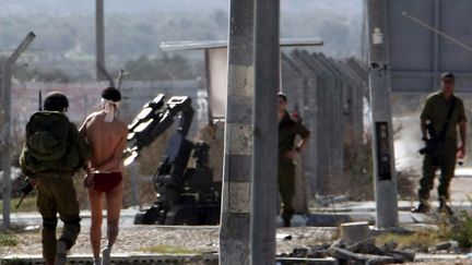 Des soldats isra&eacute;liens emm&egrave;nent un Palestinien suspect&eacute; de transporter des explosifs au checkpoint Huwara pr&egrave;s de Naplouse (Cisjordanie), le 20 d&eacute;cembre 2011. (JAAFAR ASHTIYEH / AFP)