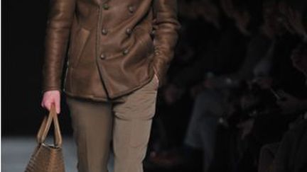 Chez Bottega Veneta, l'Hermès italien, qui a "voulu explorer l'icône du costume masculin", selon le styliste maison Tomas Maier qui a pour objectif "un look sobre et calibré". La silhouette est soulignée par la précision dans les détails: la veste est courte, les boutons jouent à cache-cache. La palette de couleurs est riche et intense. Les matières sont luxueuses.
 (TIZIANA FABI /AFP )