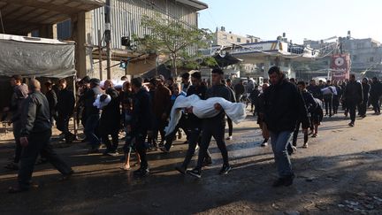 Des personnes assistent à l'enterrement de personnes tuées dans une frappe israélienne à Jabalia, dans le nord de la bande de Gaza, le 21 décembre 2024. (OMAR AL-QATTAA / AFP)