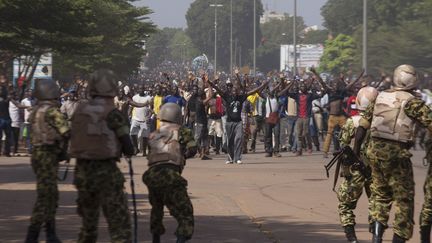 Des soldats tentent d'arr&ecirc;ter des manifestants, &agrave; Ouagadougou, au Burkina Faso, le 30 octobre 2014. (JOE PENNEY / REUTERS)