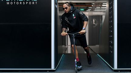 Lewis Hamilton quitte le garage de son équipe Mercedes sur une trottinette après le Grand Prix de Singapour, le 19 septembre 2019. (MOHD RASFAN / AFP)