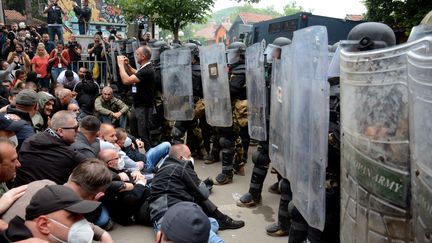 Des manifestants de la communauté serbe du Kosovo font face à la police lors d'un rassemblement pour exiger le retrait des maires albanais récemment élus, à Zveçan, dans le nord du pays, le 29 mai 2023. (AFP)