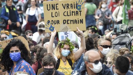 Une manifestante tient une pancarte sur laquelle on peut lire "Une vraie loi sur le climat pour demain" lors de la Marche pour le climat&nbsp; à Nantes (Loire-Atlantique), le 9 mai 2021. (SEBASTIEN SALOM-GOMIS / AFP)