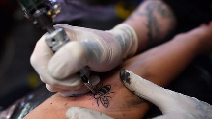 Parfois, une crème locale ou un antibiotique suffisent pour guérir, mais dans certains cas il faudra retirer le tatouage par chirurgie ou par laser. (BEN STANSALL / AFP)