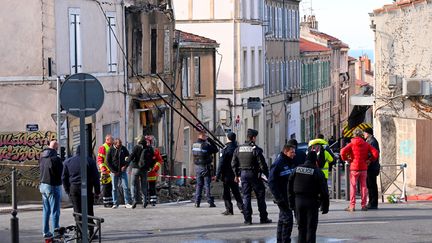 Des policiers et des marins-pompiers autour d'un immeuble partiellement effondré après un incendie, le 3 décembre 2023, à Marseille. (NICOLAS TUCAT / AFP)