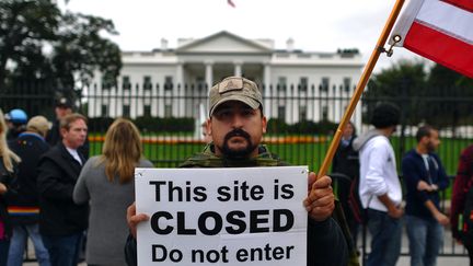 Un manifestant tient une pancarte "Ce site est ferm&eacute;. Ne pas entrer", pour demander la fin du "shutdown", le 13 octobre 2013, devant la Maison Blanche, &agrave; Washington. (JEWEL SAMAD / AFP)