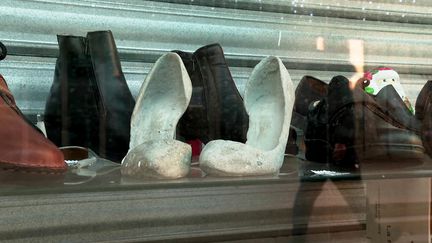 Des chaussures en béton au milieu des chaussures en cuir exposées dans une vitrine du centre-ville de Montpellier (France 3 Occitanie)