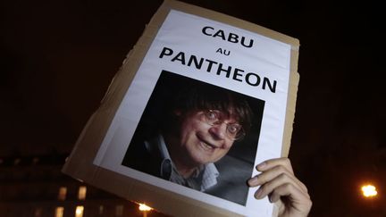 A man holds up a placard bearing the picture of late cartoonist Cabu and reading "Cabu to the pantheon" during a gathering at the Place de la Republique (Republic square) in Paris, on January 7, 2015 (JOEL SAGET / AFP)