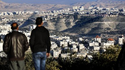 Deux hommes observent les colonies juives de&nbsp;Ma'aleh Adumim, en Cisjordanie, le 23 janvier 2017. (THOMAS COEX / AFP)