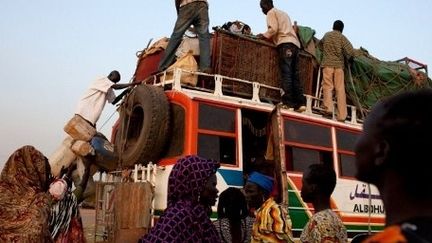 Des Soudanais se préparent à emprunter le long voyage vers l'exile. (YASUYOSHI CHIBA / AFP)