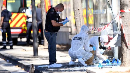 Des policiers inspectent un Abribus percuté par un véhicule, son conducteur a été interpellé, lundi 21 août 2017 à Marseille. (BORIS HORVAT / AFP)