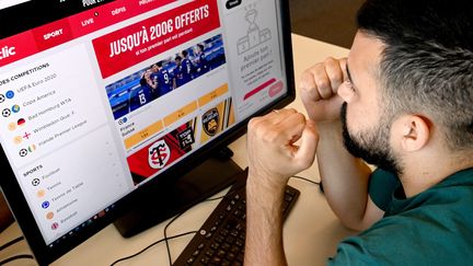 Un joueur regarde un site de paris sportifs. (MARC OLLIVIER / MAXPPP)