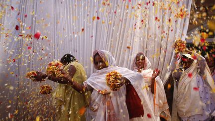 Des veuves jettent des fleurs en l'air &agrave; l'occasion du festival des couleurs &agrave; Vrindavan (Inde), le 24 mars 2013. (VIVEK PRADESH / REUTERS)