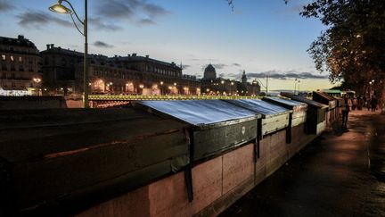 Les boîtes vertes à livres des bouquinistes, dans la nuit parisienne, le 3 novembre 2023. (MAGALI COHEN / HANS LUCAS / AFP)