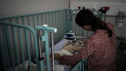 Une femme s'occupe de son enfant au service d'urgence pédiatrique du CHU de Bordeaux, le 3 novembre 2022. (PHILIPPE LOPEZ / AFP)