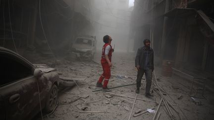 Un membre du croissant rouge syrien cherche des survivants près de Damas (Syrie) le 13 décembre 2015. (ABD DOUMANY / AFP)